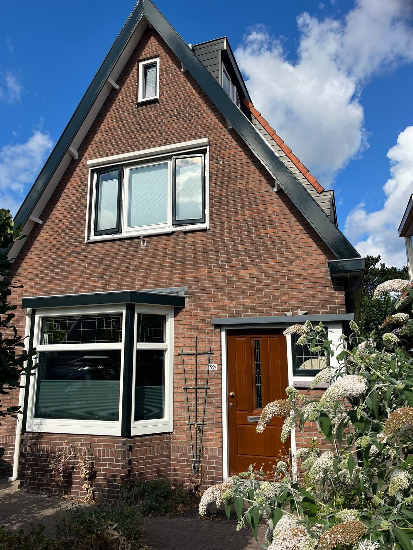 Vrijstaande woning met pas geschilderde kozijnen en een groene erker