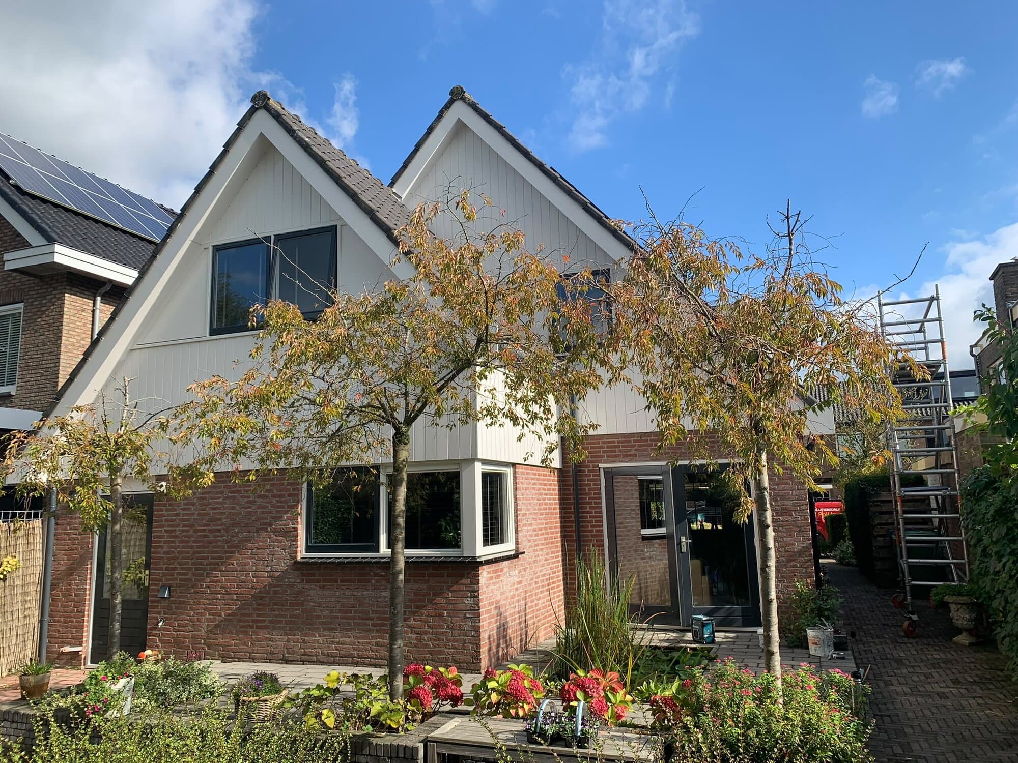 Vrijstaande woning met witte gevelbekleding en pas geschilderde kozijnen
