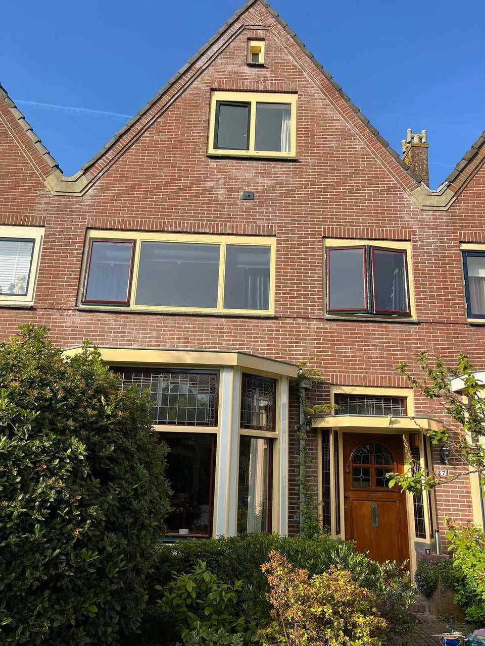 Karakteristieke bakstenen woning met pas geschilderde crèmekleurige kozijnen