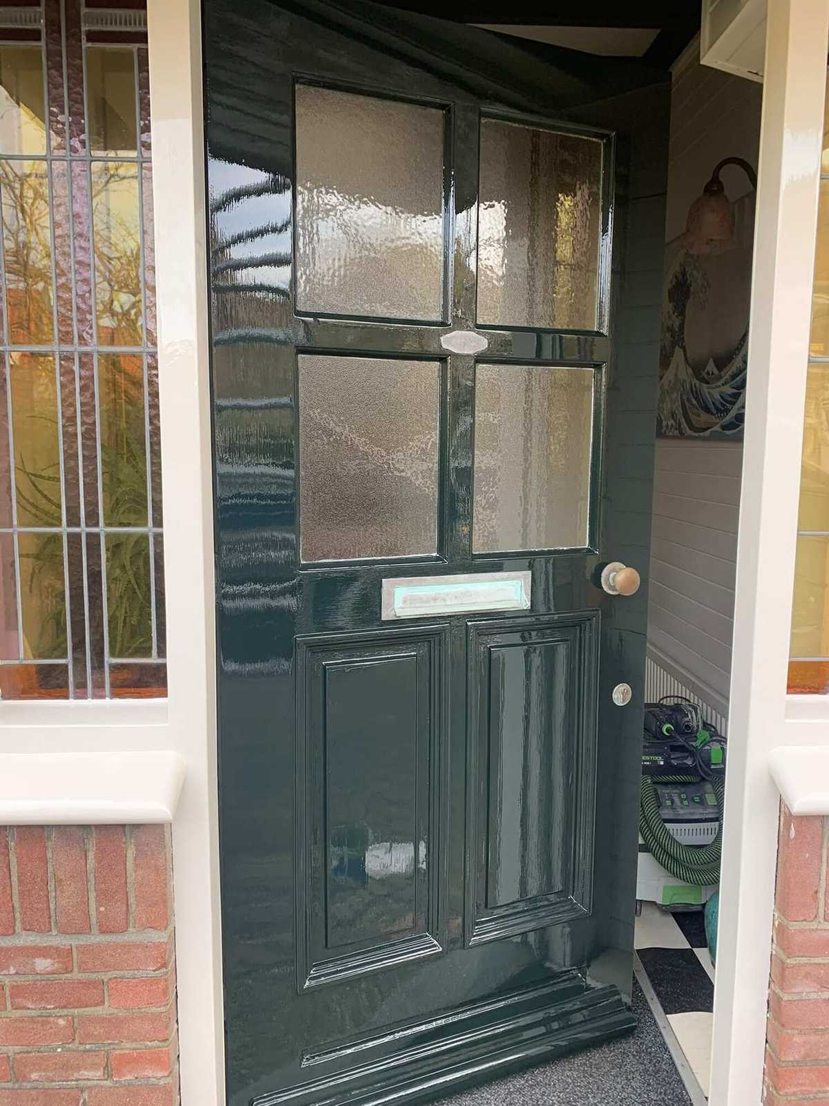 Donkergroene voordeur met glas in lood na het schilderwerk