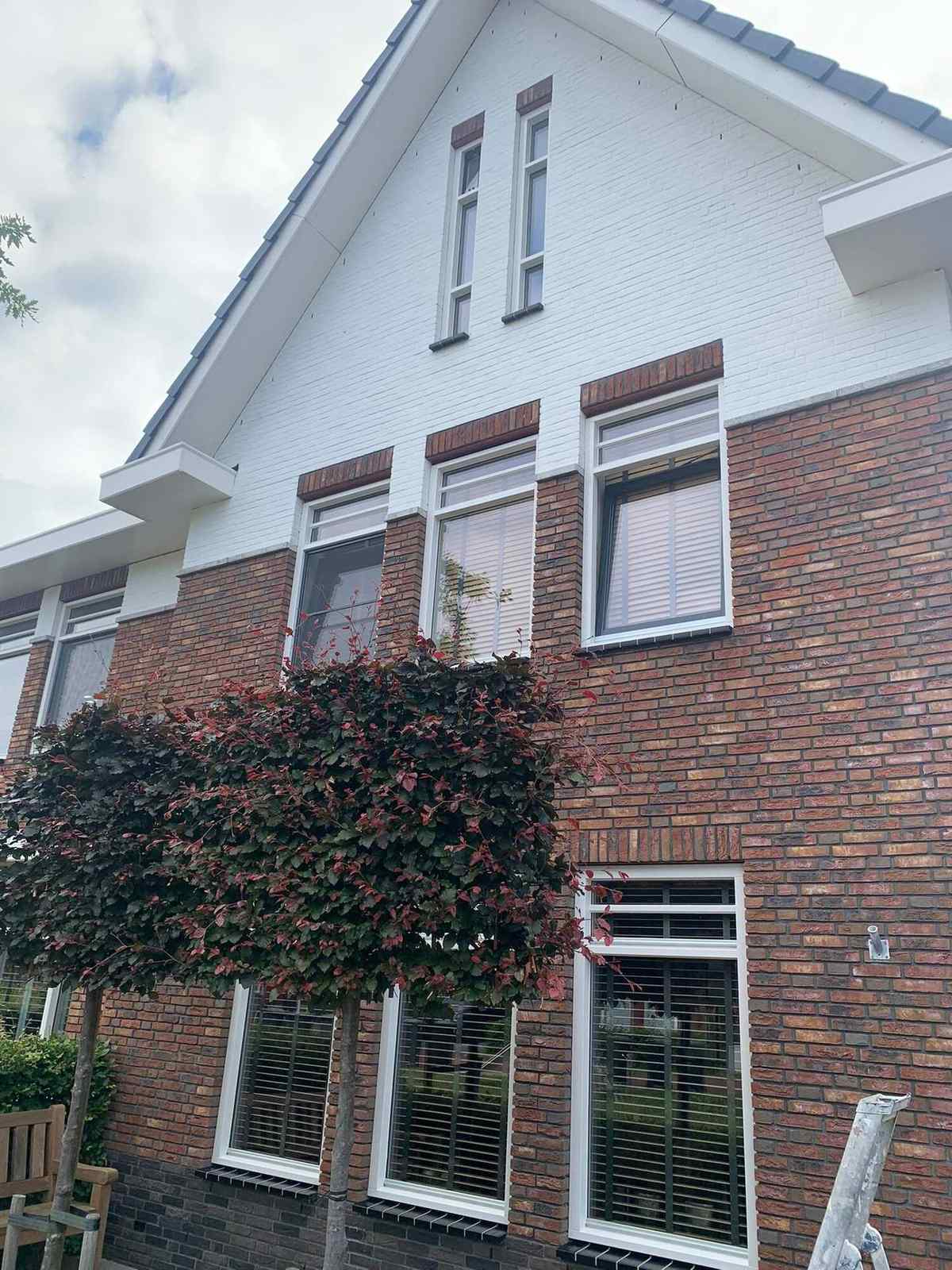 Moderne vrijstaande woning in Heiloo met witte gevelbanden boven het metselwerk
