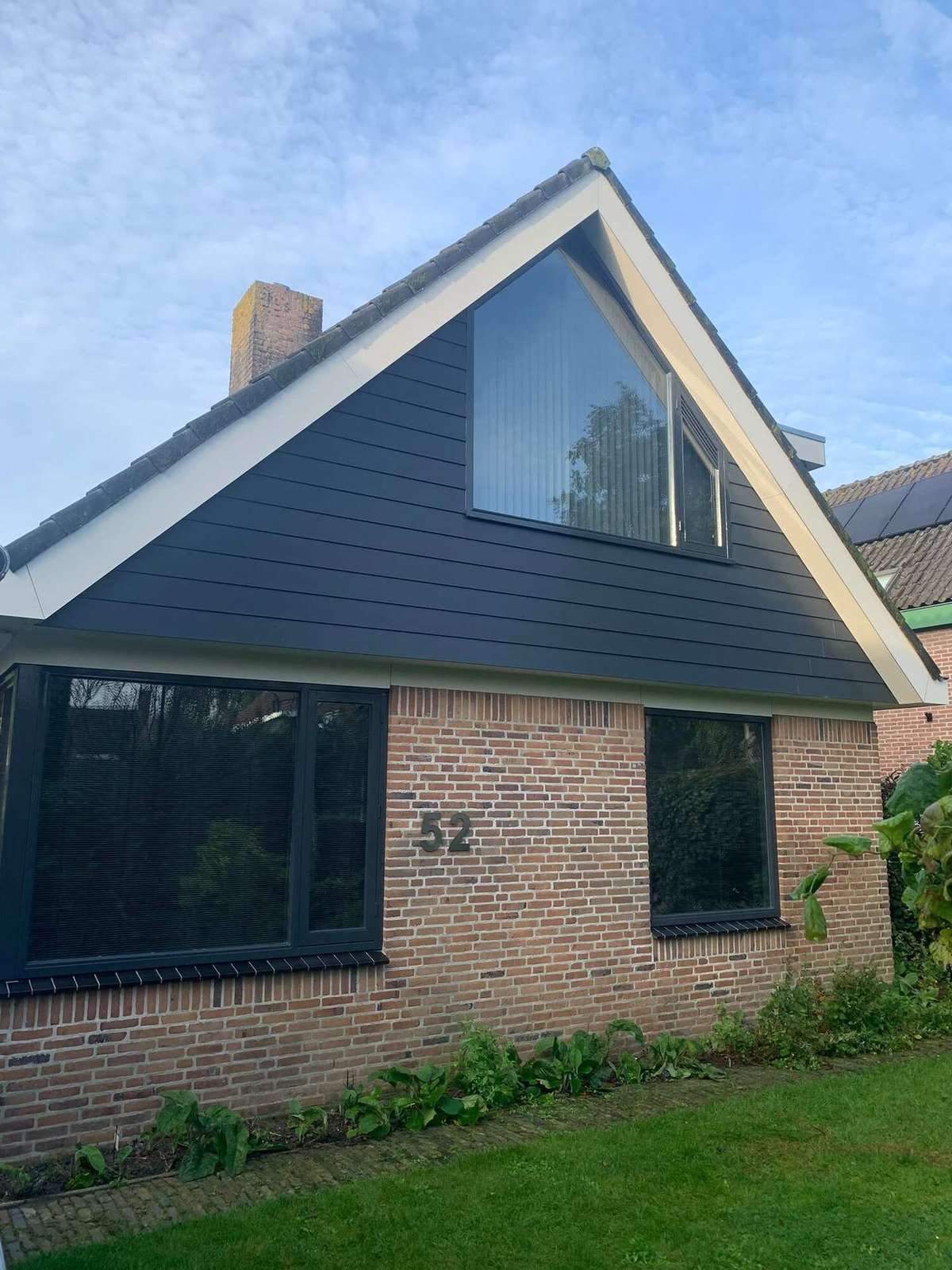 Vrijstaande woning in Heiloo met donkere gevelbetimmering onder de puntgevel