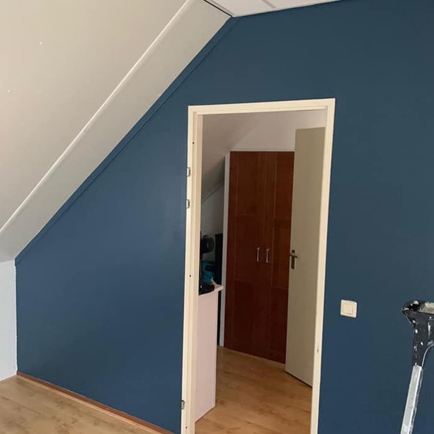 Diepblauw geschilderde wand met een wit deurkozijn